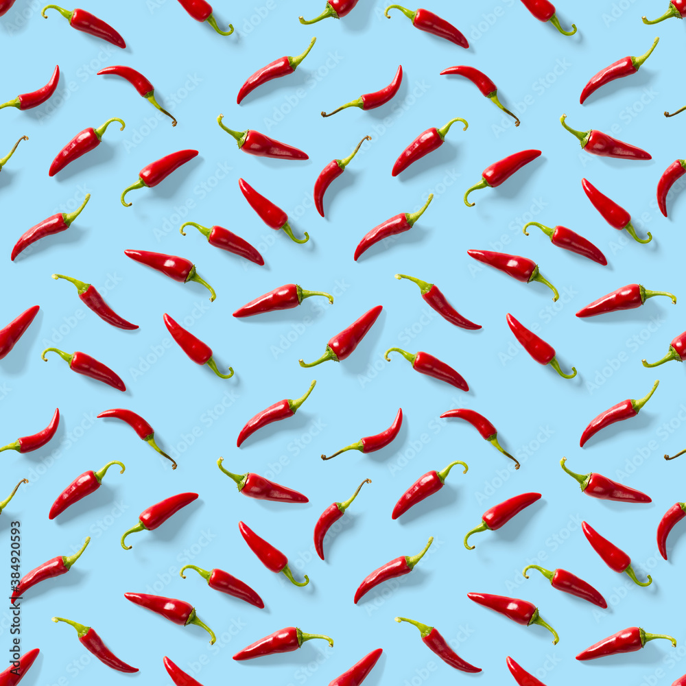 Seamless pattern made of red chili or chilli on blue background. Minimal food pattern. Red hot chilli seamless peppers pattern. Food background. Seamless pattern made of red chili or chilli on blue background. Minimal food pattern. Red hot chilli seamless peppers pattern. Food background.