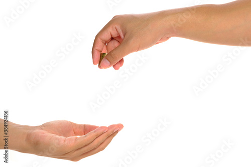 hand of a rich people giving some gold coins to another person hand in white background