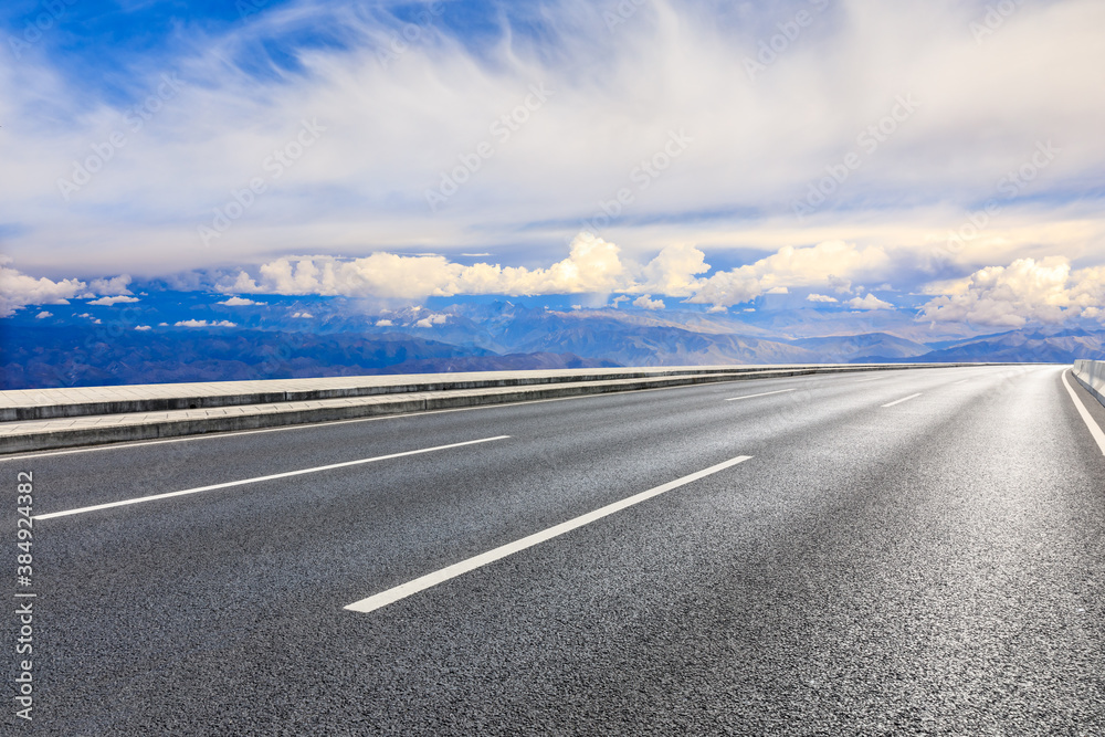 Fototapeta premium Asphalt road and mountain with sky clouds landscape.
