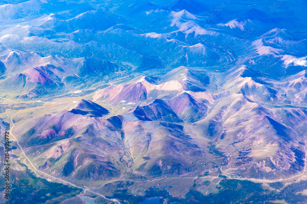 Obraz premium Aerial view above the clouds and colorful mountain on a sunny day.mountain view from airplane.