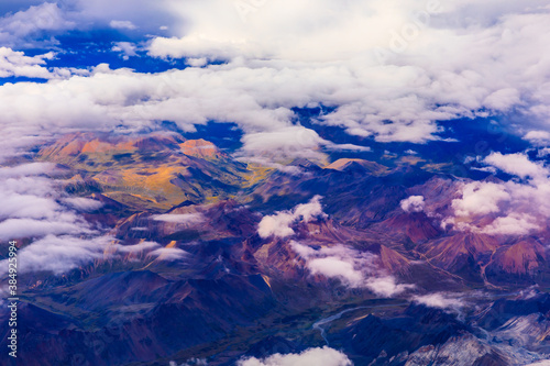 Aerial view above the clouds and colorful mountain on a sunny day.mountain view from airplane.