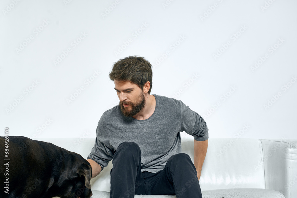 Man with a pet dog on the couch fun friends emotions light room