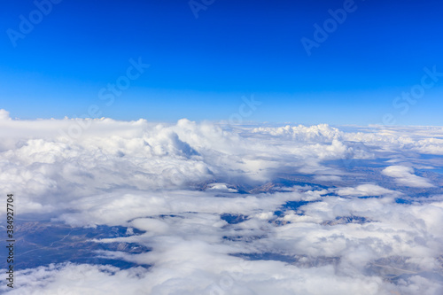 Fototapeta Naklejka Na Ścianę i Meble -  Aerial view above the clouds and mountain peaks on a sunny day.mountain view from airplane.