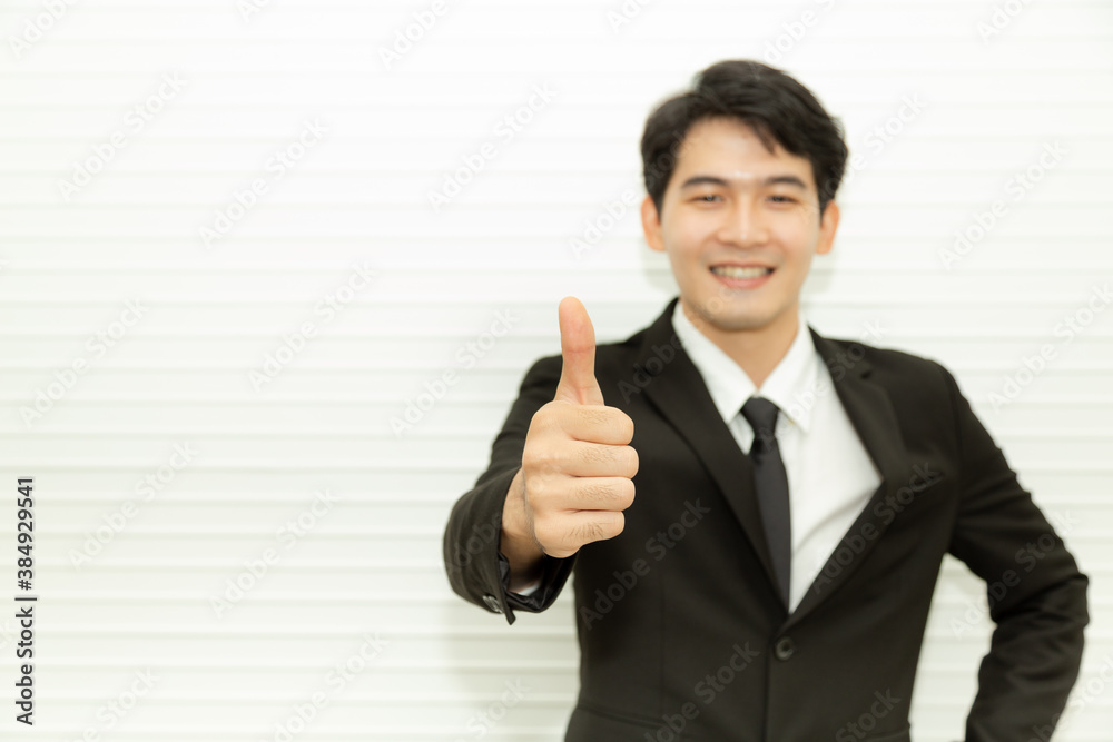 Young success businessman with black suite thumbs up posing and smiling at camera. Business and office concept Young success businessman with black suite thumbs up posing and smiling at camera. Business and office concept