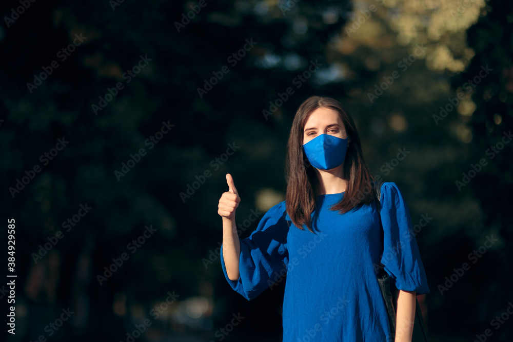 Optimistic Woman Wearing a Face Mask Holding Thumbs Up Optimistic Woman Wearing a Face Mask Holding Thumbs Up