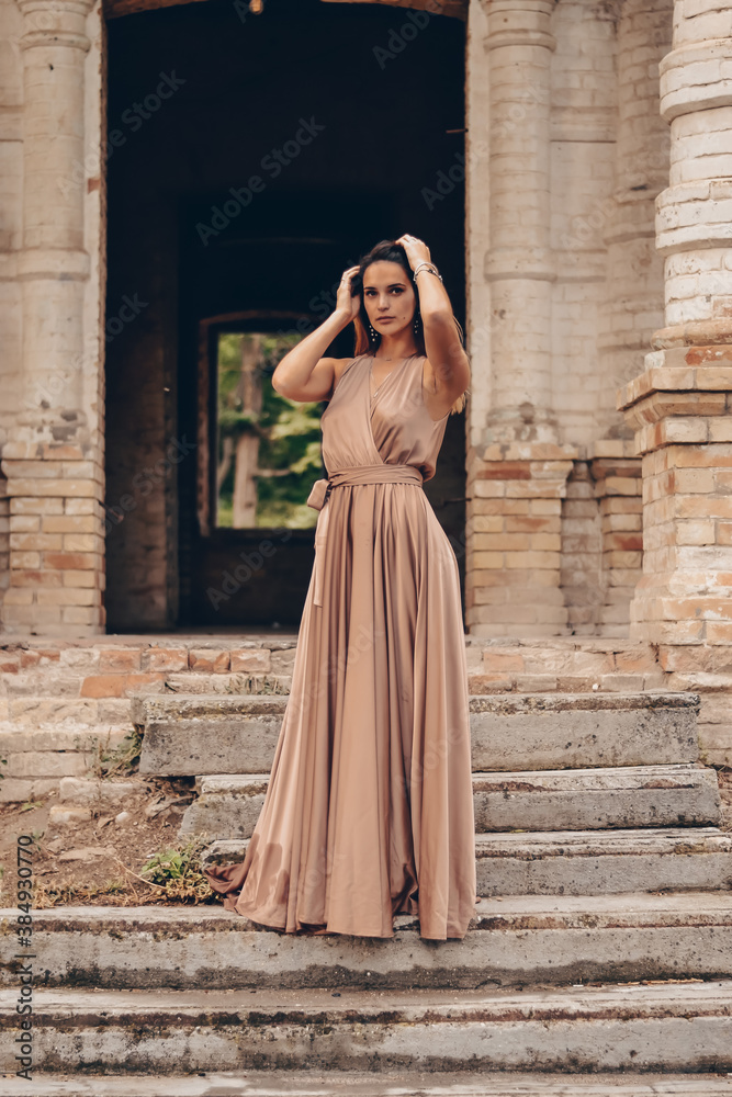 young beautiful girl in a silk dress in an old manor