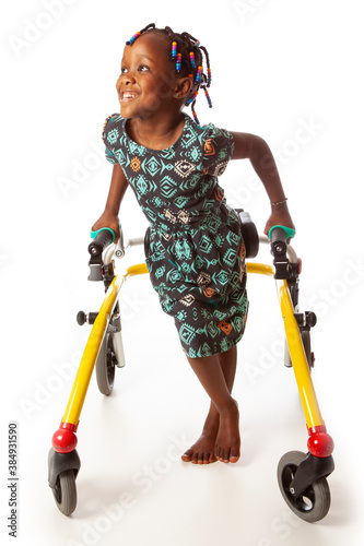 Fotografía Young girl with CP and a walker on white.