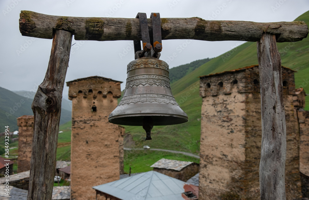 Fototapeta premium The old church copper bell on wooden supports, village of Ushguli, Svaneti, Georgia. The authentic village in Caucasus mountains, the one of the highest continuously inhabited settlements in Europe.