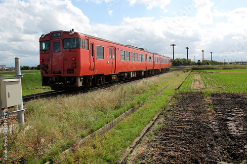 田んぼ道を颯爽と走るオレンジのレトロな電車