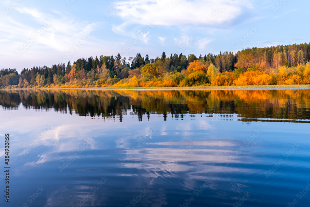 Banner overlooking a lake with bright blue water and a shore with an autumn forest reflected in the water Banner overlooking a lake with bright blue water and a shore with an autumn forest reflected in the water