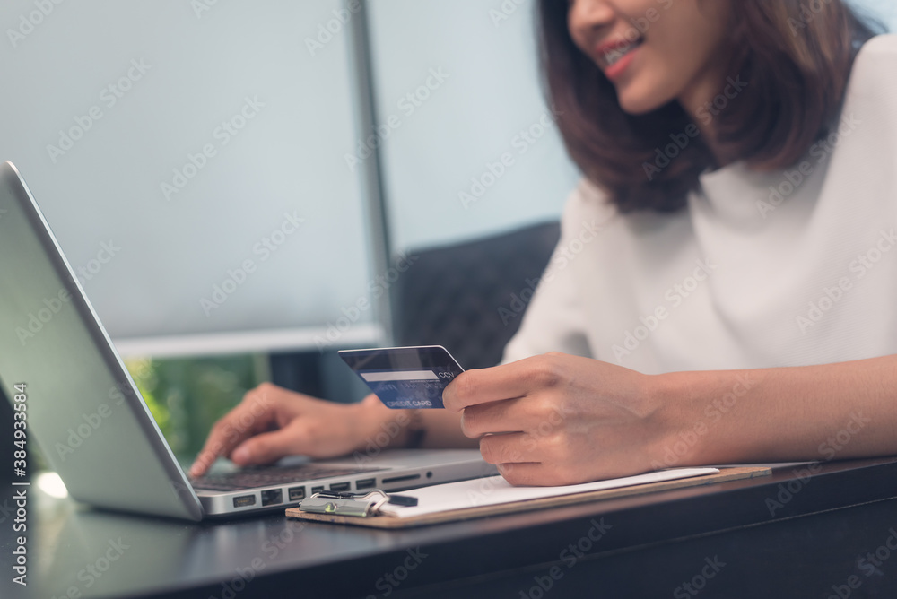 Women hand holding credit cards for online shopping with laptop Women hand holding credit cards for online shopping with laptop