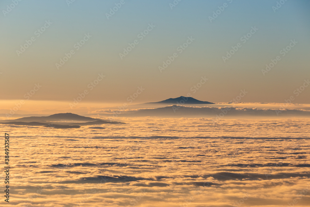Sea of fog and mist between mountains and hills at sunset