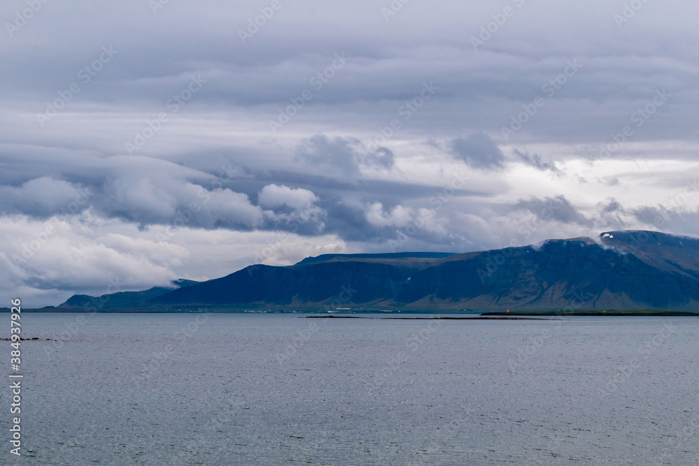 Landscape picture of sea and mountain at cloudy day in Iceland.