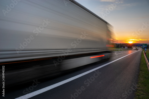 truck speeding up on the highway going towards the setting sun