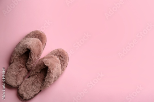 Pair of stylish soft slippers on pink background, flat lay. Space for text