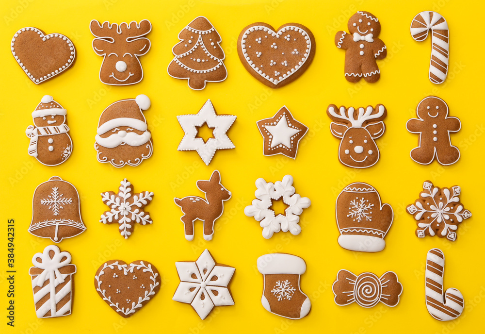 Different Christmas gingerbread cookies on yellow background, flat lay - obrazy, fototapety, plakaty 