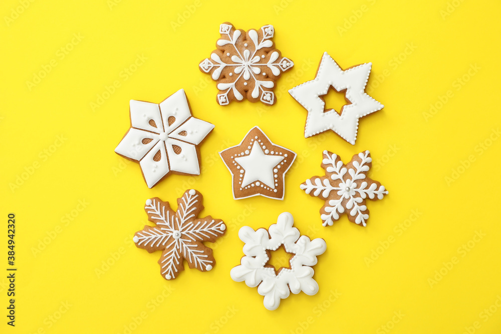 Christmas snowflake shaped gingerbread cookies on yellow background, flat lay - obrazy, fototapety, plakaty 