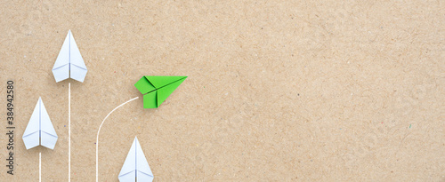 Group of white paper plane in one direction and one green paper plane pointing in different way. Business for innovative solution concept, copy space photo