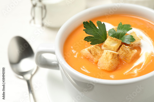 Delicious pumpkin soup served on white table, closeup