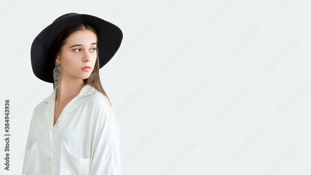 Trend fashion look. Female elegance. Stylish woman in straw black hat vintage earrings white blouse isolated on neutral copy space. Boho lifestyle. Advertising background Trend fashion look. Female elegance. Stylish woman in straw black hat vintage earrings white blouse isolated on neutral copy space. Boho lifestyle. Advertising background