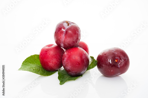 plums with plum leaves isolated on a white background