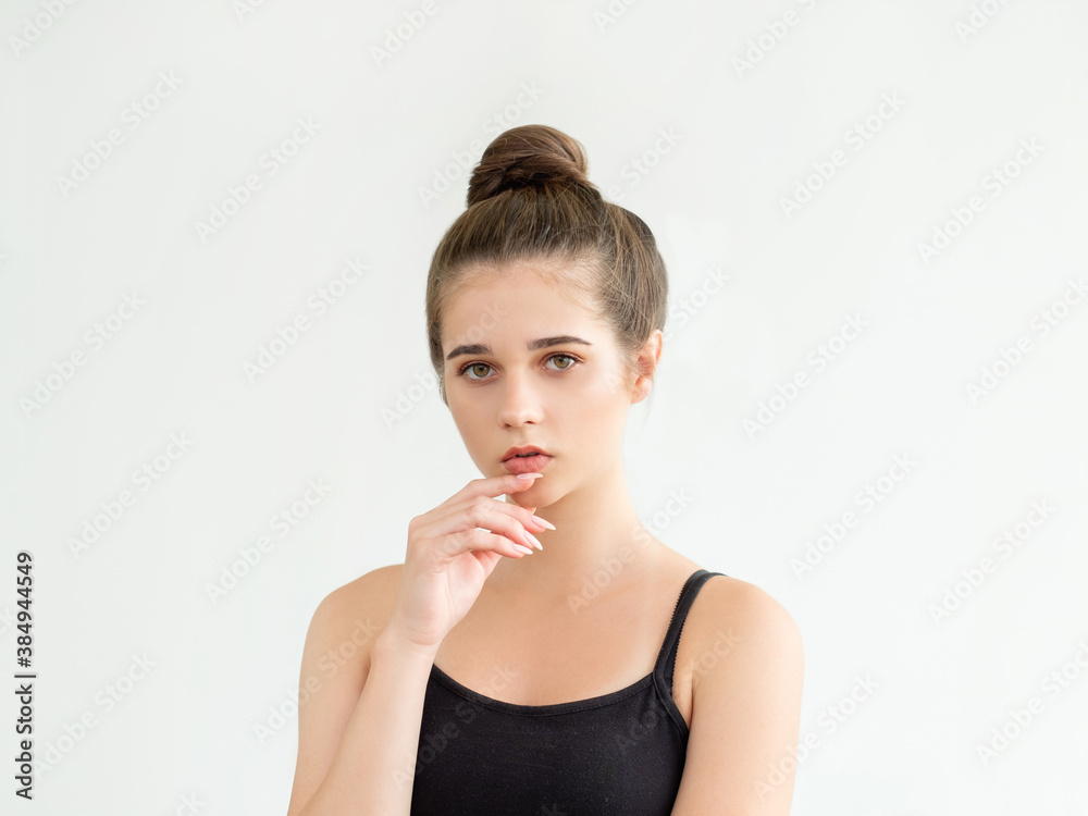 Make decision. Casual elegance. Thoughtful pretty woman in black sleeveless top and bun hairstyle looking at camera isolated on white. Feeling doubt. Aesthetic cosmetology. Make decision. Casual elegance. Thoughtful pretty woman in black sleeveless top and bun hairstyle looking at camera isolated on white. Feeling doubt. Aesthetic cosmetology.