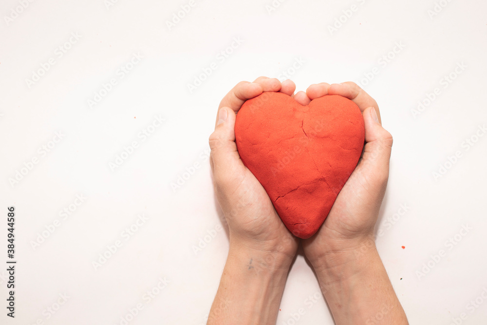 Obraz premium heart of red kinetic sand on a white background. the concept of Valentine's day
