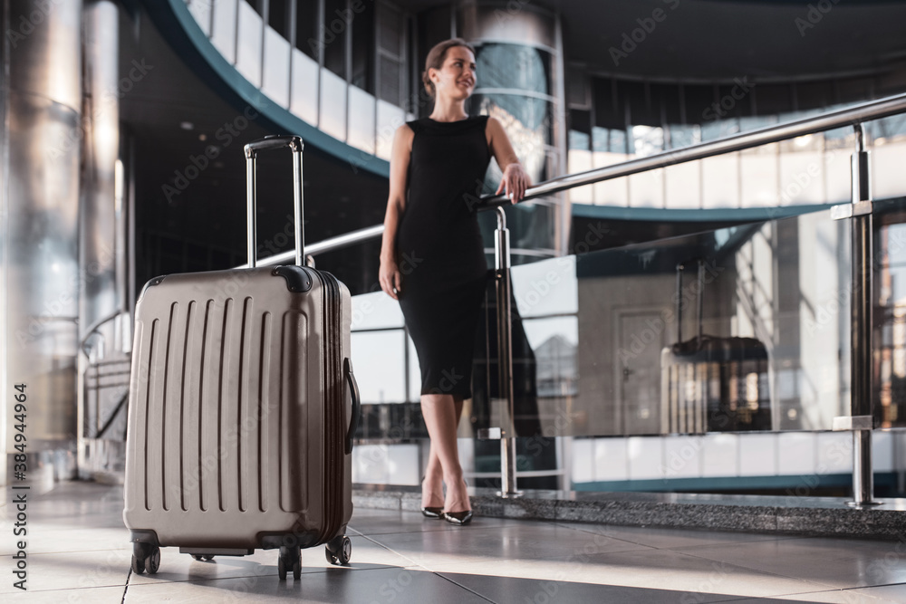 Large and convenient suitcase accompanies a woman while travelling