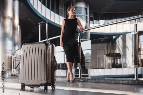 Large and convenient suitcase accompanies a woman while travelling