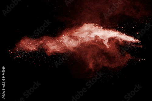 Brown powder explosion on black background.