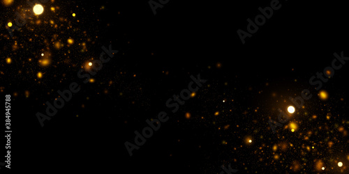 Abstract background with golden glitter dust. Glowing lights, sparkling particles on black.