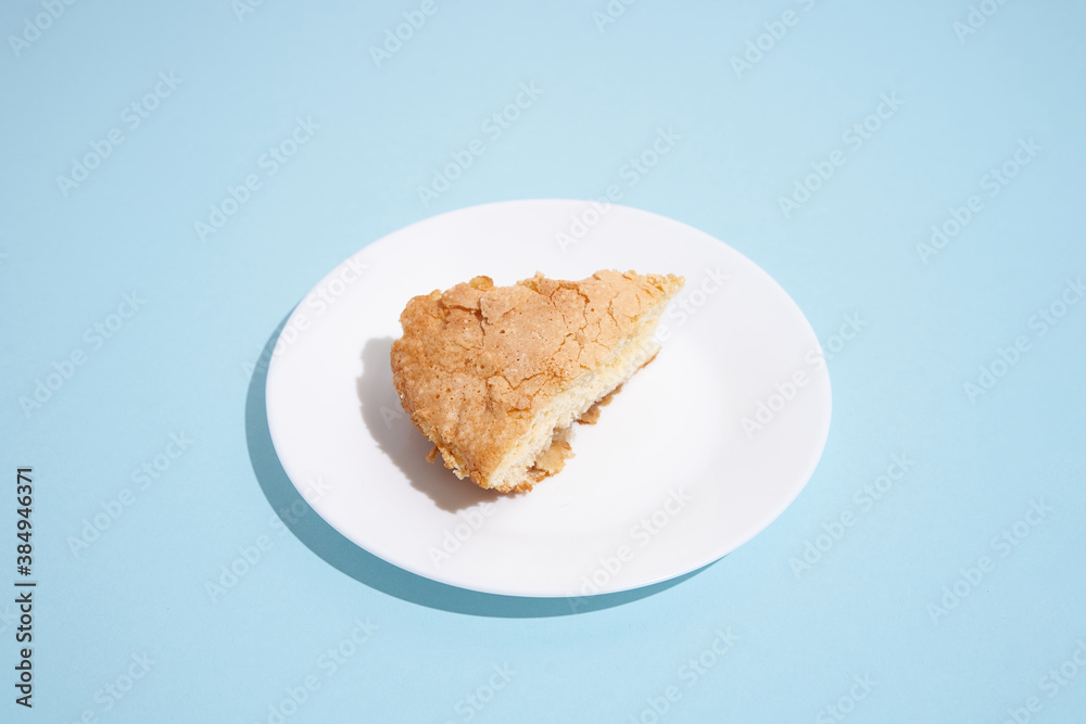 pattern of apple pie slices on white plate on blue background. trendy food pattern with shadow pattern of apple pie slices on white plate on blue background. trendy food pattern with shadow
