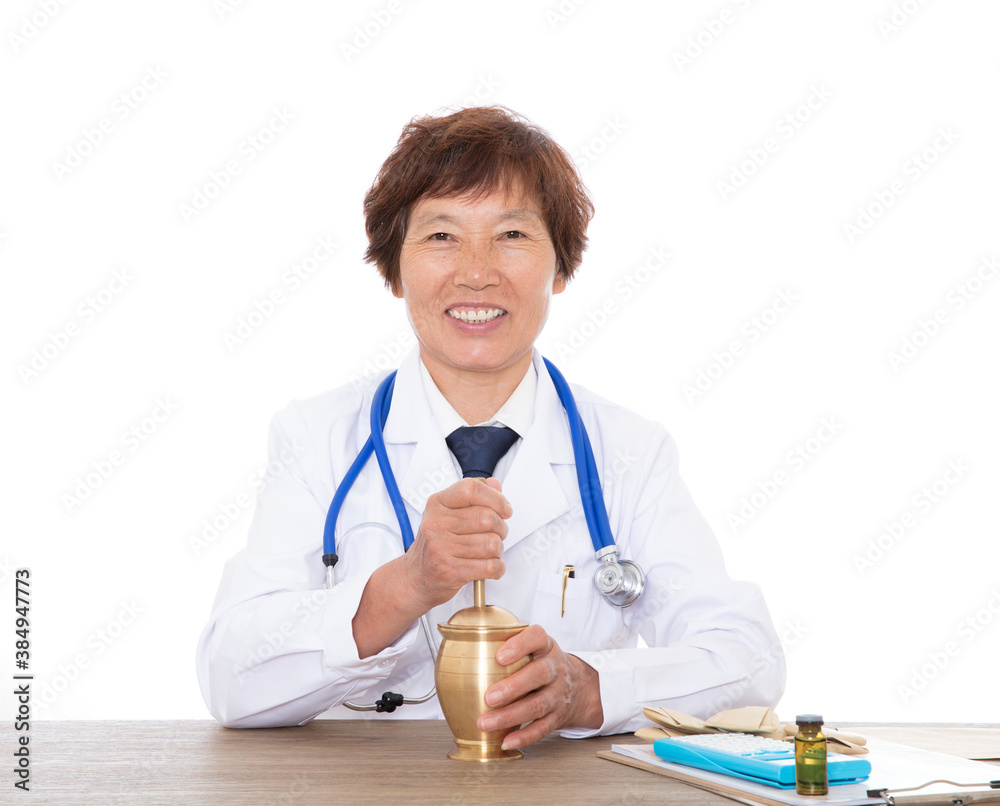 Senior Chinese pharmacist smiles and looks at the camera while using medicine mortar to pound medicine Senior Chinese pharmacist smiles and looks at the camera while using medicine mortar to pound medicine