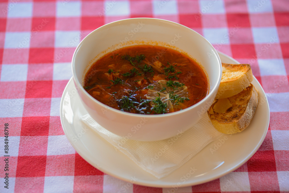 Traditional Ukrainian Russian soup, Borscht. Beetroot soup in bowl on wooden board and rustic wooden background Traditional Ukrainian Russian soup, Borscht. Beetroot soup in bowl on wooden board and rustic wooden background