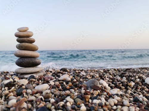 The art of balance made of stones on the beach. Mediterranean in the background.