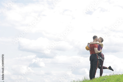 love couple in helmets outdoor activities nature, rope climbing park, against the sky