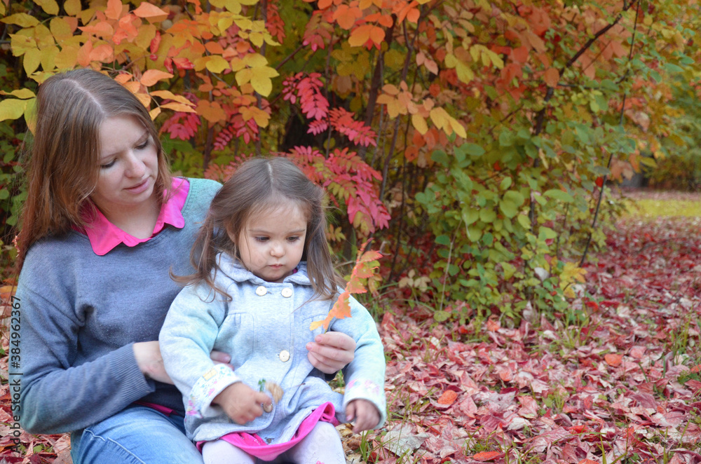 Young mother and her toddler girl have fun in autumn park Young mother and her toddler girl have fun in autumn park
