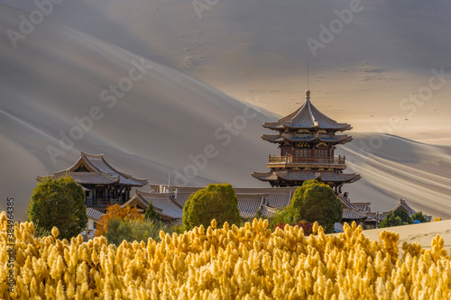 Mingyue Pavilion inside the Crescent Lake Oasis and desert background. This is a famous place part of the silk road in Dunhuang, China.