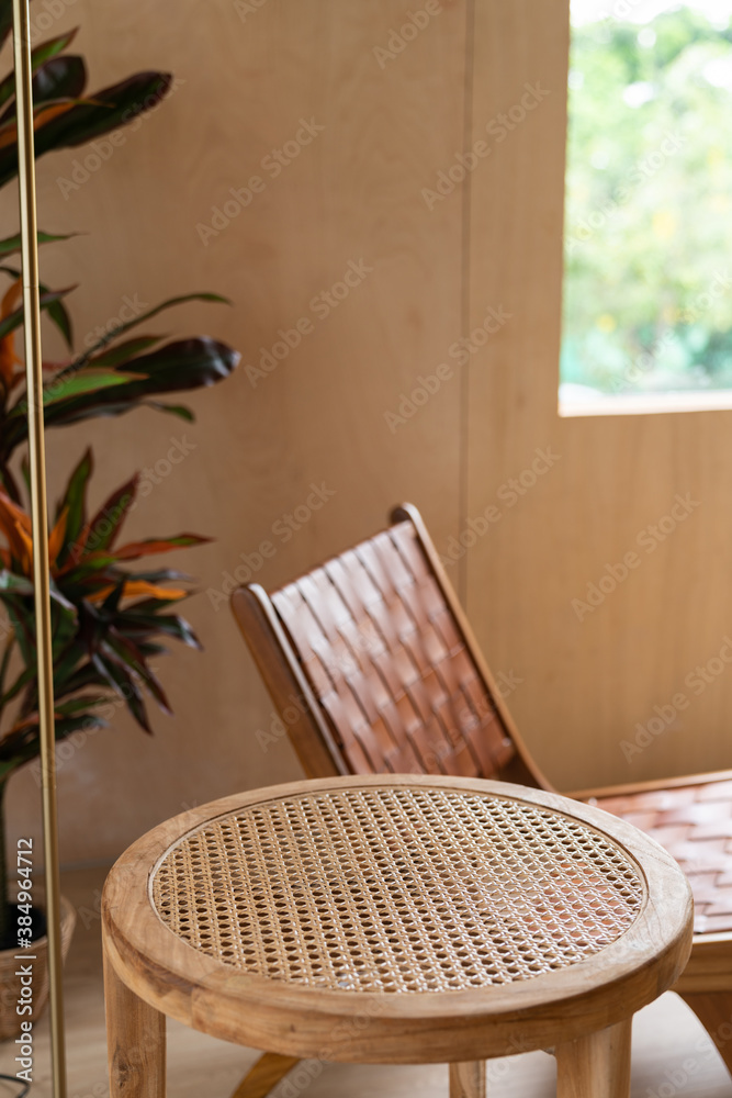 Obraz premium Stylish living corner setting with ceramic vase on rattan wood table and artificial plant in basket in the background / cozy interior design / copy space