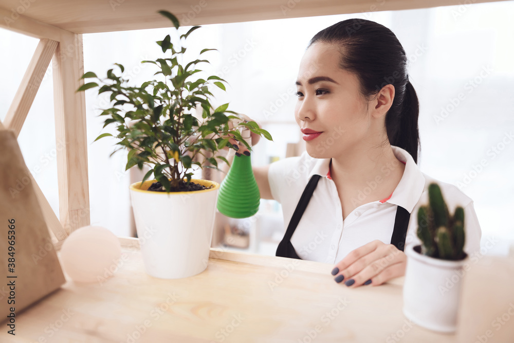 Joyful Asian maid sprayed with atomizer plant.