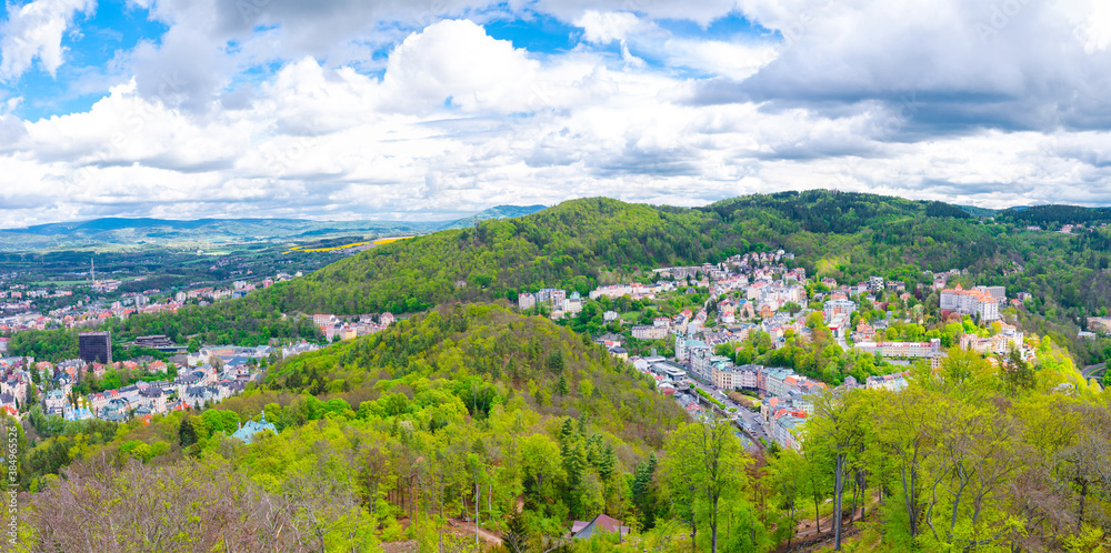 Karlovy Vary city aerial panoramic view with row of colorful multicolored buildings and spa hotels in historical city centre. Panorama of Karlsbad town and Slavkov Forest hills, Czech Republic