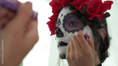 Concepto de Carnaval o Halloween. Mujer maquillaje de calavera mexicana blanca en espejo, usa ropa negra en un escenario de miedo 4K photo