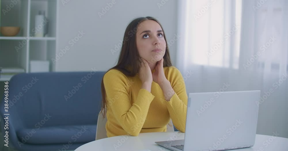 Tired woman suffering from neck pain working till on laptop. a woman has a sore neck after hard work at a table with a laptop. Pain in the neck. Tired woman suffering from neck pain working till on laptop. a woman has a sore neck after hard work at a table with a laptop. Pain in the neck.