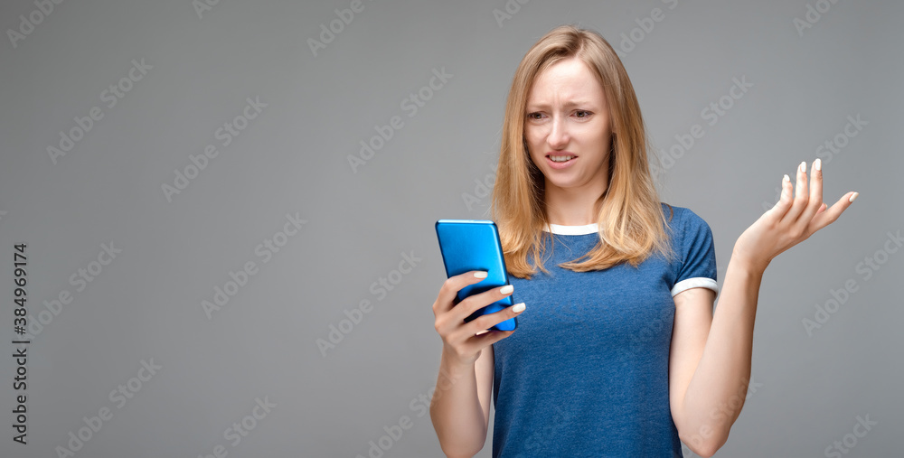 Disturbed girl has concerned face expression, holds smartphone, cannot understand whats wrong Disturbed girl has concerned face expression, holds smartphone, cannot understand whats wrong