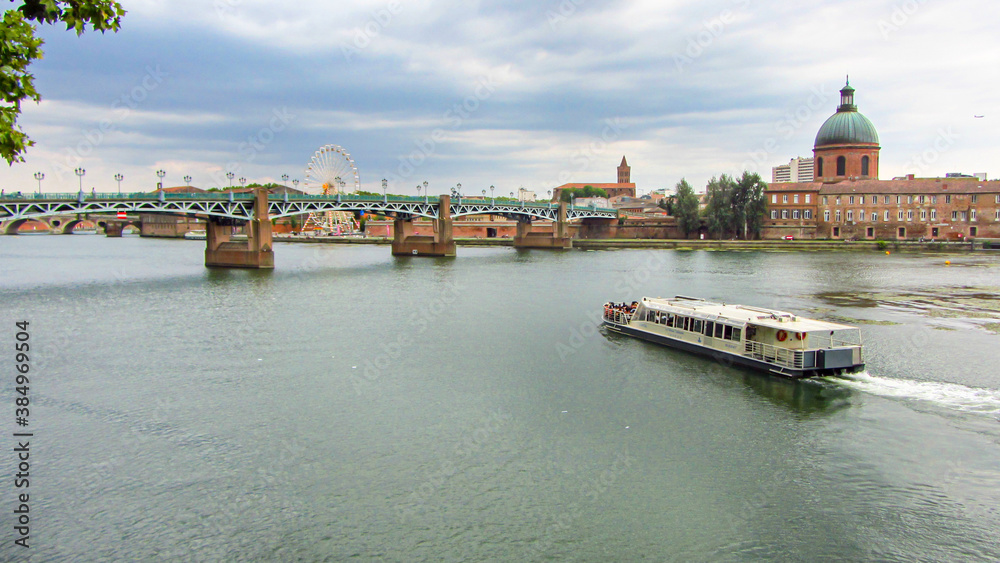 Fototapeta premium Panoramic of ferry Saint-Pierre Bridge over Garonne river and Dome de la Grave in Toulouse, France. Touristic landmark in Europe.