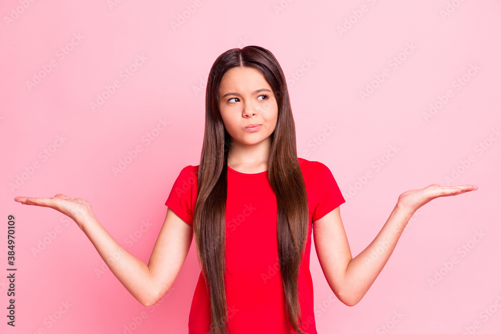 Photo of unsure kid girl hold hand look empty space for advertisement wear red t-shirt isolated on pastel color background - obrazy, fototapety, plakaty 