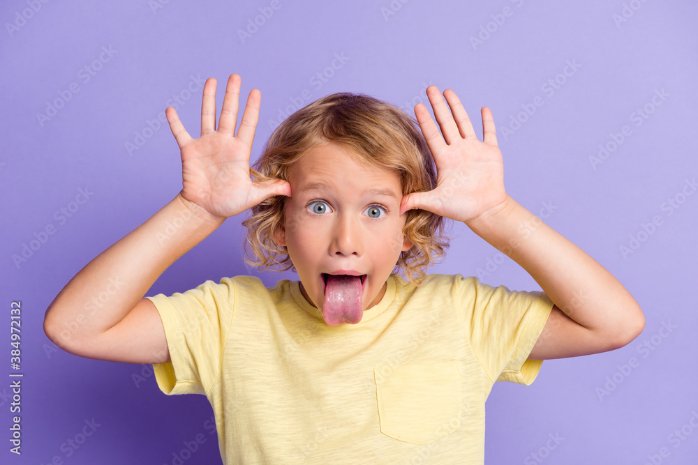 Portrait of small kid boy make funny face show tongue out isolated over violet color background Portrait of small kid boy make funny face show tongue out isolated over violet color background