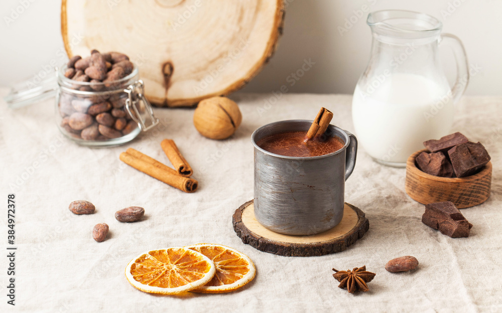 Hot chocolate in a metal mug with a cinnamon stick on the tablecloth. Copy space Hot chocolate in a metal mug with a cinnamon stick on the tablecloth. Copy space