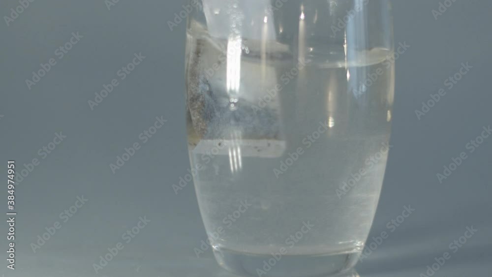 Tea bag being moved in glass of hot water in slow motion Tea bag being moved in glass of hot water in slow motion