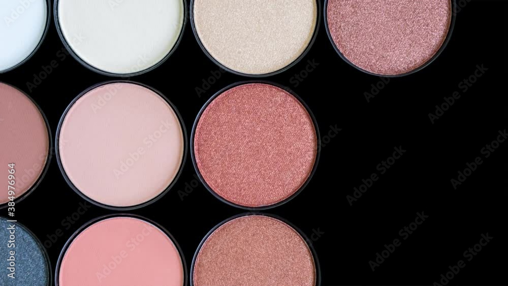 Multicolored beautiful brown eyeshadow palette on black background. Isolated. Beauty products. Makeup cosmetics. Trendy eye shadow, face blush. Bright colorful stop motion animation. Looping video.